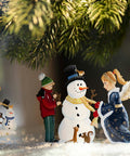 Engel und Kind schmücken Schneemann
