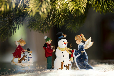 Engel und Kind schmücken Schneemann